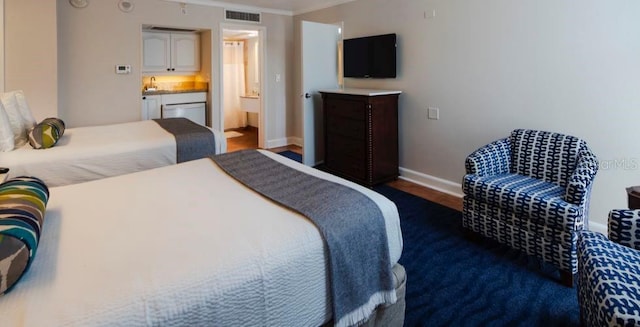 bedroom featuring sink, crown molding, and connected bathroom