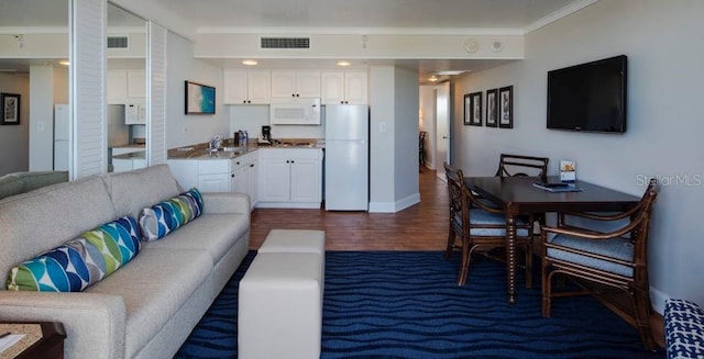 living room with hardwood / wood-style floors, radiator heating unit, crown molding, and sink