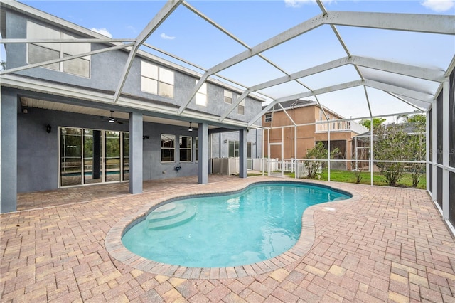 view of pool featuring ceiling fan, glass enclosure, and a patio area