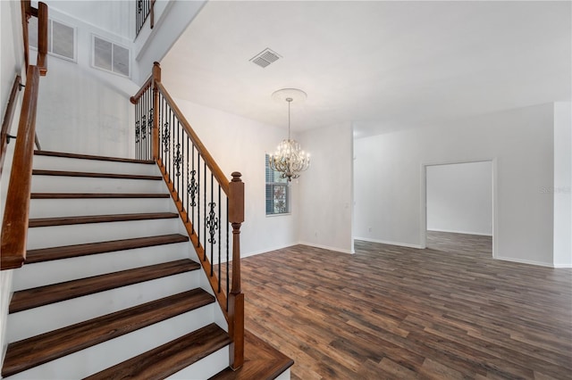 staircase featuring wood-type flooring and a chandelier