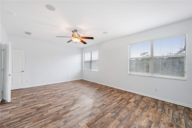 spare room featuring dark wood-type flooring and ceiling fan