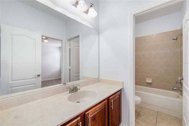 full bathroom with tile patterned flooring, vanity, tiled shower / bath combo, and toilet