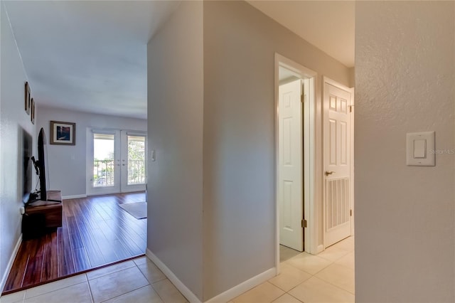 hallway with french doors and light tile patterned flooring