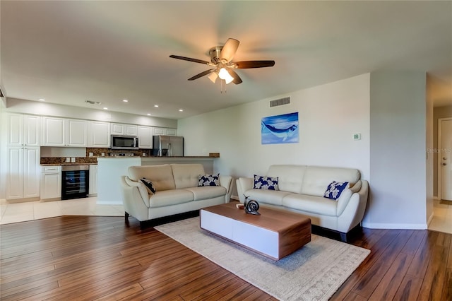 living room featuring wine cooler, ceiling fan, and light hardwood / wood-style floors