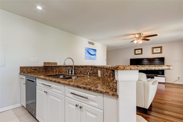 kitchen with dark stone countertops, dishwasher, sink, and white cabinets