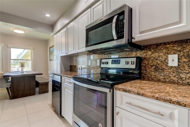 kitchen featuring backsplash, dark stone counters, light tile patterned floors, white cabinetry, and stainless steel appliances