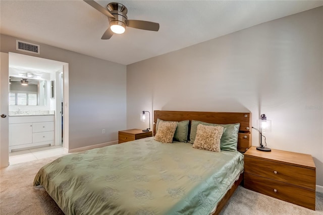 bedroom with ensuite bathroom, ceiling fan, light colored carpet, and sink