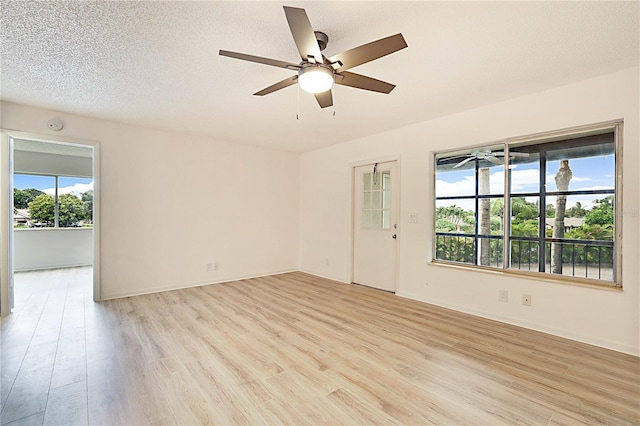 empty room featuring ceiling fan, light hardwood / wood-style flooring, and a textured ceiling