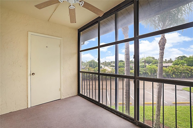 unfurnished sunroom with ceiling fan