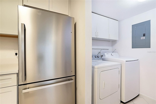 washroom with separate washer and dryer, light tile patterned floors, electric panel, and cabinets