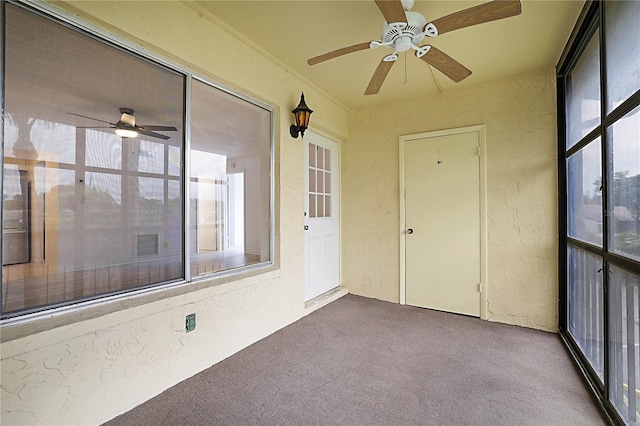 unfurnished sunroom with ceiling fan