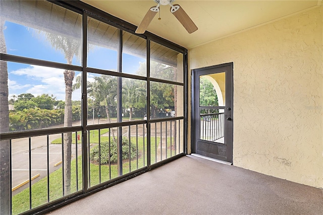 unfurnished sunroom with ceiling fan