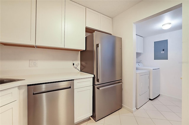 kitchen with appliances with stainless steel finishes, white cabinets, light tile patterned floors, electric panel, and independent washer and dryer