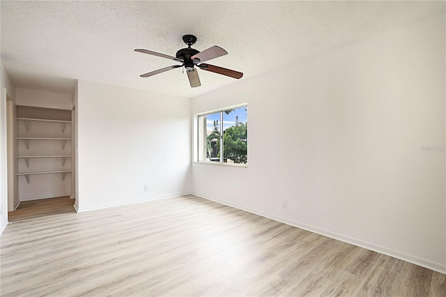 unfurnished room featuring ceiling fan, light hardwood / wood-style floors, and a textured ceiling