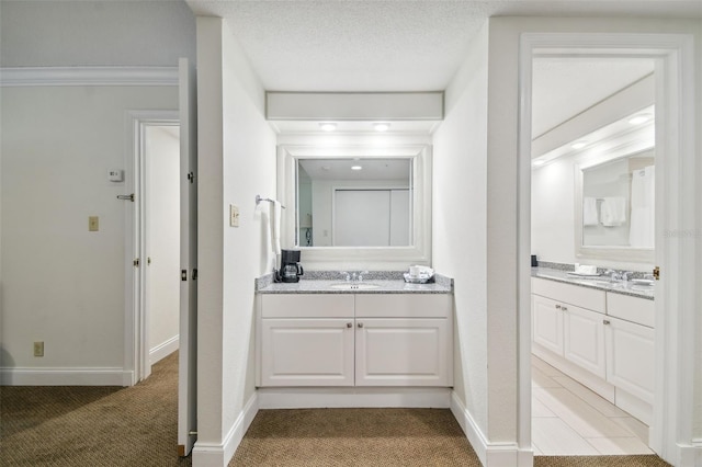 bathroom with a textured ceiling, vanity, and crown molding