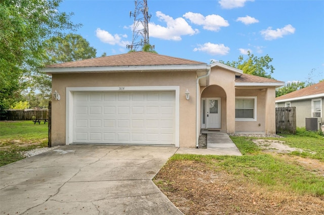 view of front of home featuring central AC unit, a garage, and a front lawn