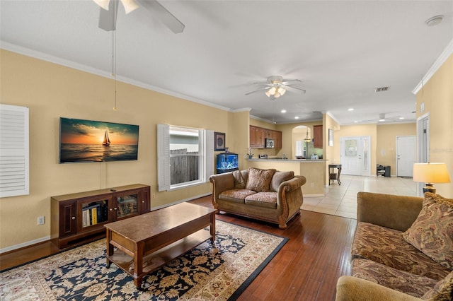 living room featuring ceiling fan, light hardwood / wood-style flooring, and ornamental molding