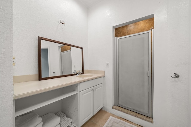 bathroom featuring tile patterned flooring, vanity, and a shower with shower door