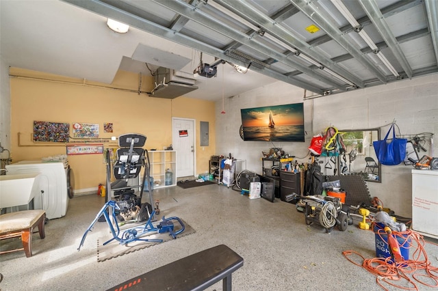 garage with electric panel, washer and clothes dryer, and a garage door opener