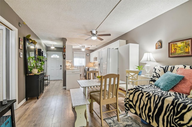 interior space with light hardwood / wood-style flooring, ceiling fan, and a textured ceiling