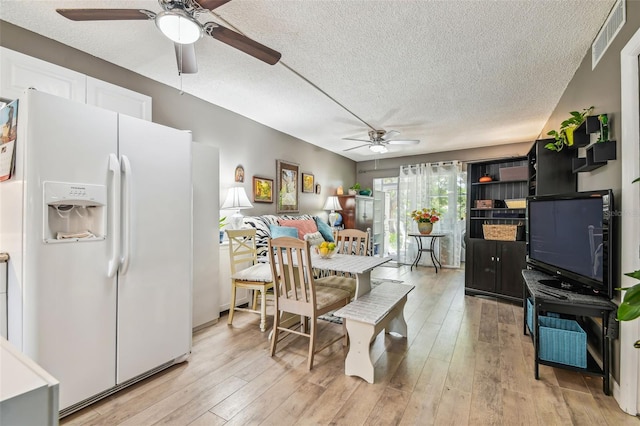 dining area featuring a textured ceiling, ceiling fan, and light hardwood / wood-style floors