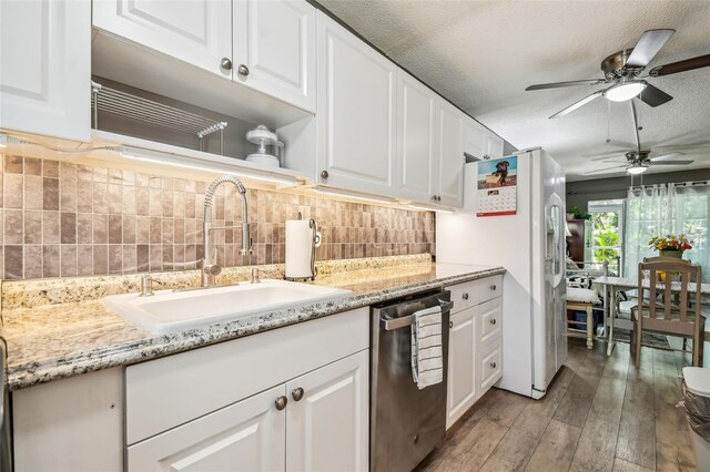 kitchen with tasteful backsplash, white cabinets, dishwasher, hardwood / wood-style floors, and sink