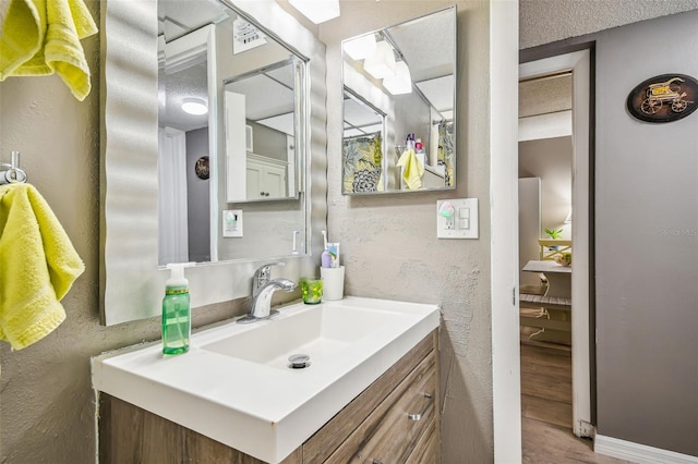 bathroom featuring vanity, wood-type flooring, and a textured ceiling