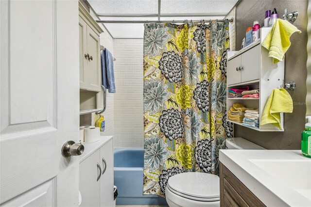 full bathroom with shower / tub combo, toilet, vanity, and a textured ceiling