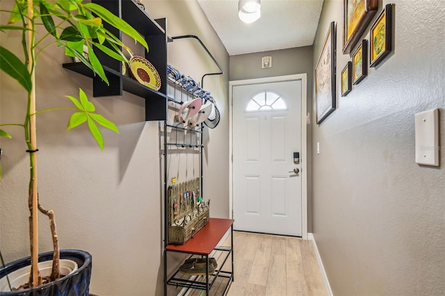 entryway with light hardwood / wood-style flooring and a textured ceiling