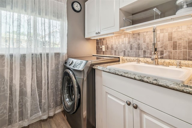 laundry room featuring wood-type flooring, cabinets, and sink