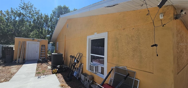 view of side of property with cooling unit and central AC unit