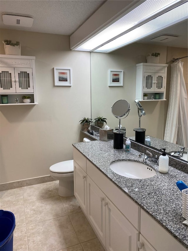 bathroom with vanity, tile patterned floors, a textured ceiling, and toilet