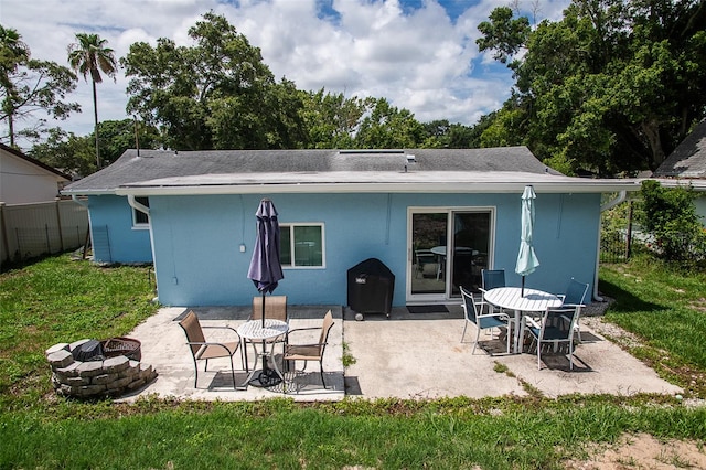 back of house featuring a yard, an outdoor fire pit, and a patio area