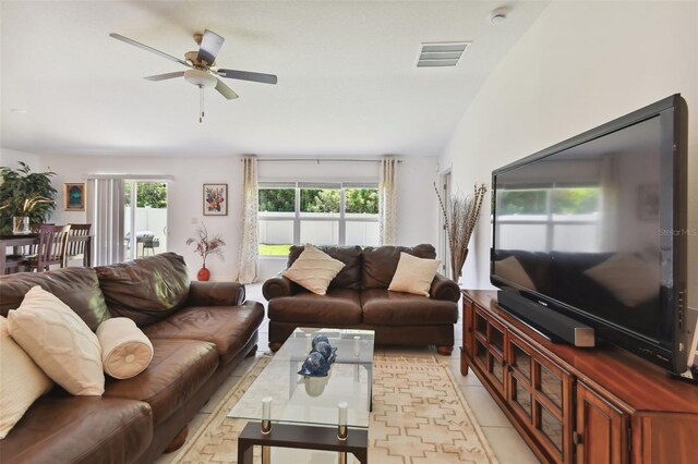 living room featuring lofted ceiling, ceiling fan, and light tile patterned flooring