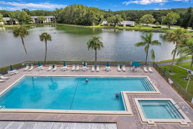 view of swimming pool featuring a patio and a water view