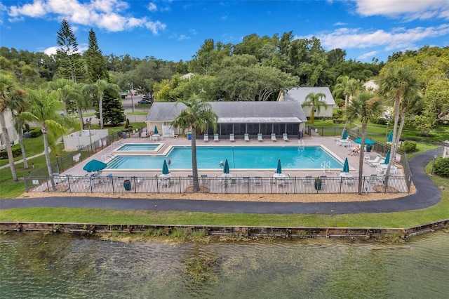 view of pool with a patio area and a water view