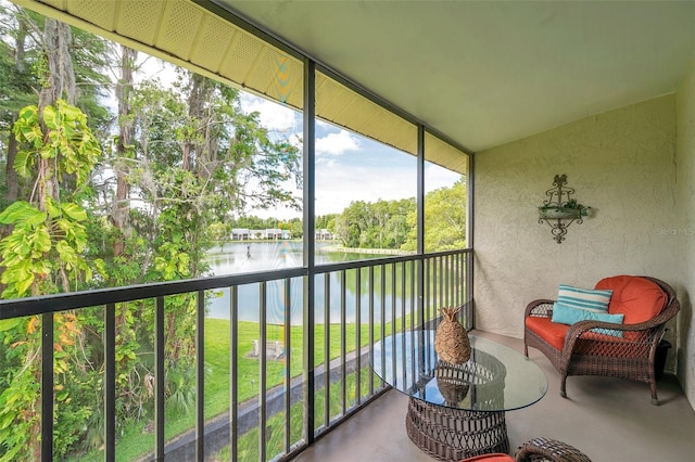 sunroom featuring a water view