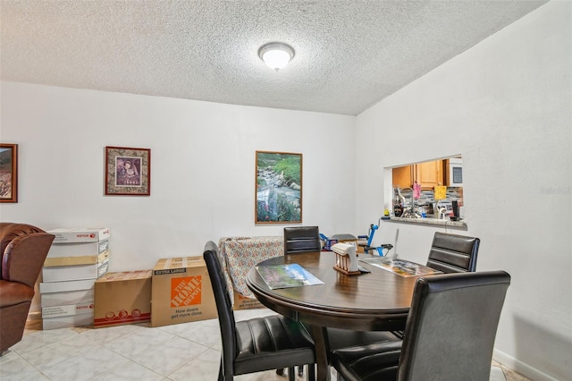 tiled dining area with a textured ceiling