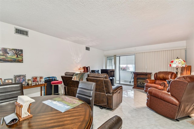 living room with a textured ceiling and light tile floors