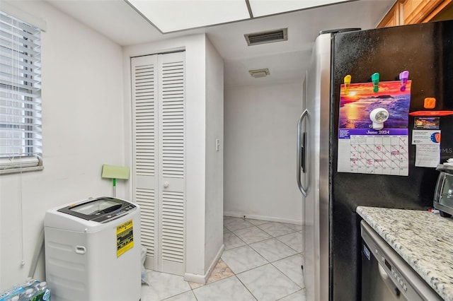 interior space with light stone counters, appliances with stainless steel finishes, and light tile floors