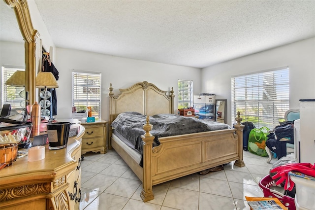 bedroom with a textured ceiling, multiple windows, and light tile floors