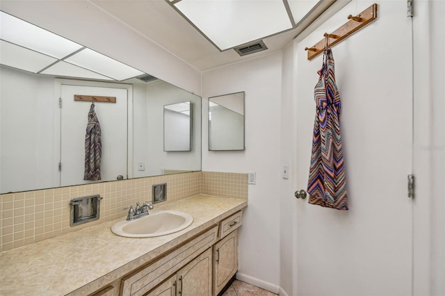 bathroom featuring tile flooring, tasteful backsplash, and large vanity