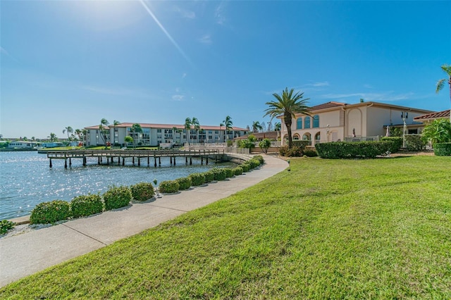 dock area featuring a lawn and a water view