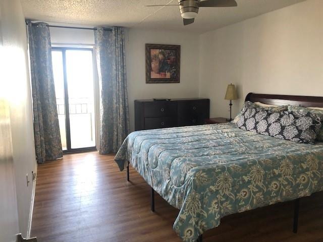 bedroom with a textured ceiling, ceiling fan, and wood-type flooring