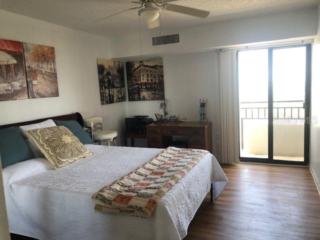 bedroom featuring a textured ceiling, ceiling fan, and hardwood / wood-style floors