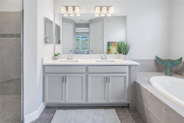 bathroom featuring tiled tub, tile patterned floors, and vanity