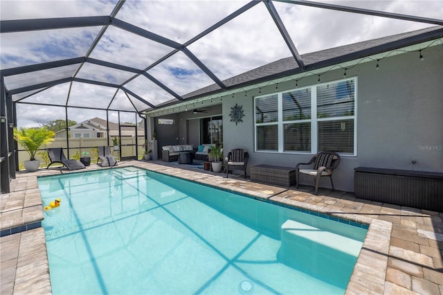 view of pool with glass enclosure, a patio area, outdoor lounge area, and ceiling fan