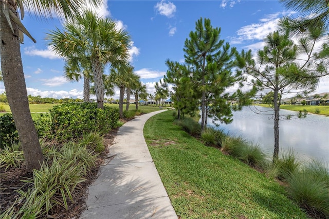 view of property's community with a water view and a yard