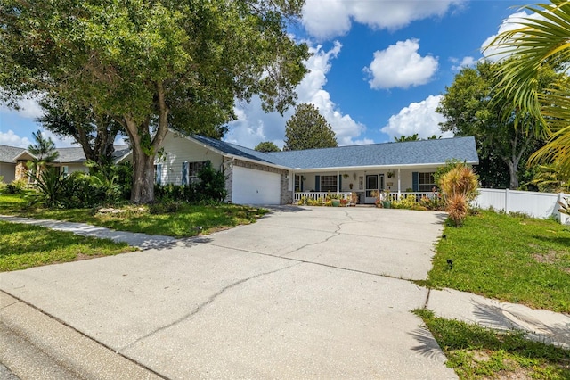 ranch-style house with covered porch, a front yard, and a garage