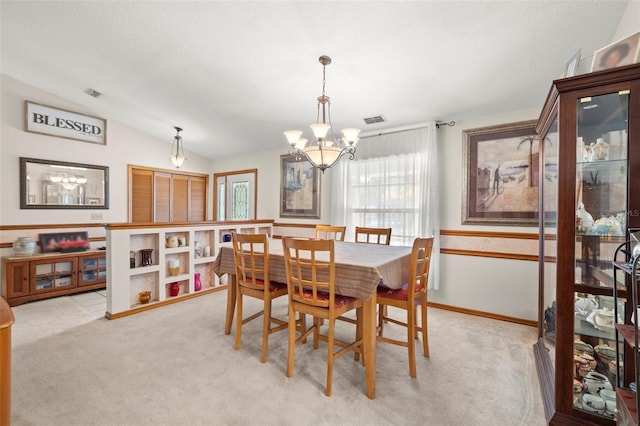 carpeted dining room featuring vaulted ceiling and a notable chandelier